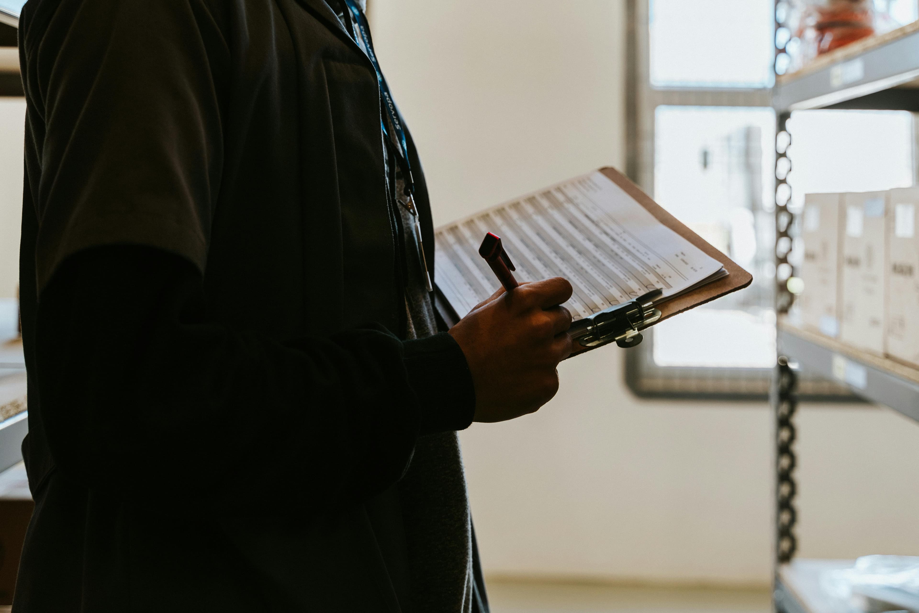 Authenticator inspecting an item with a clipboard